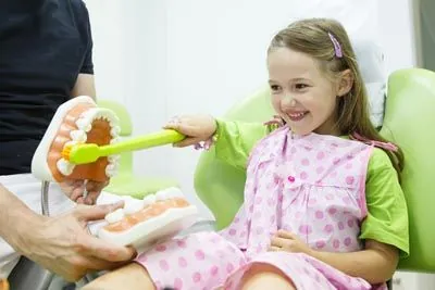 young girl showing how she brushes her teeth